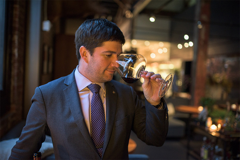 Man taking a sip of red wine